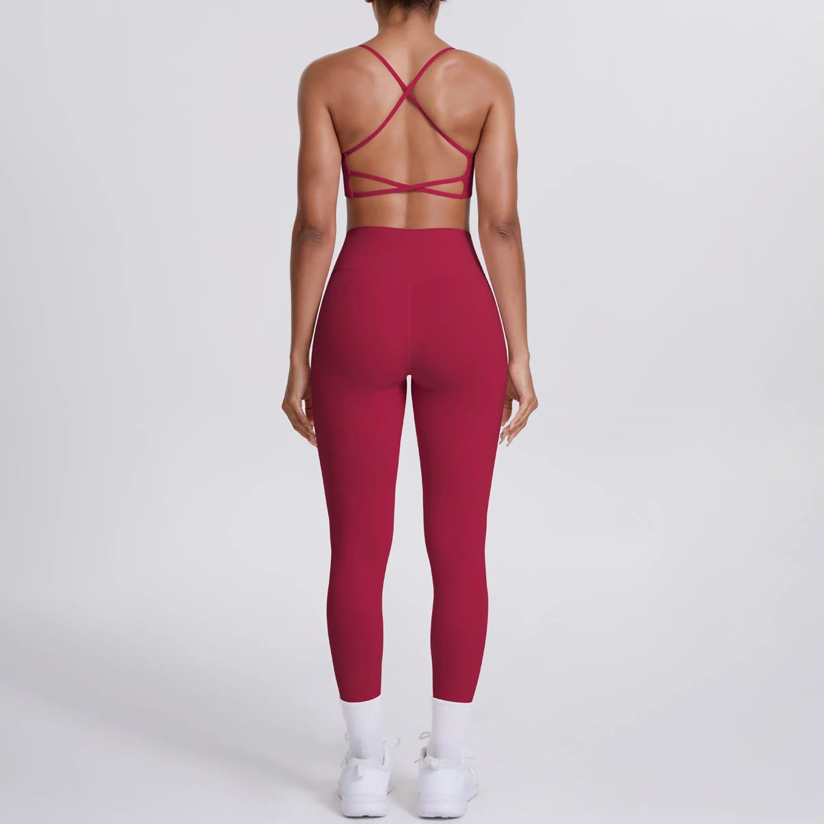Person wearing a red sports bra and leggings set on a white background