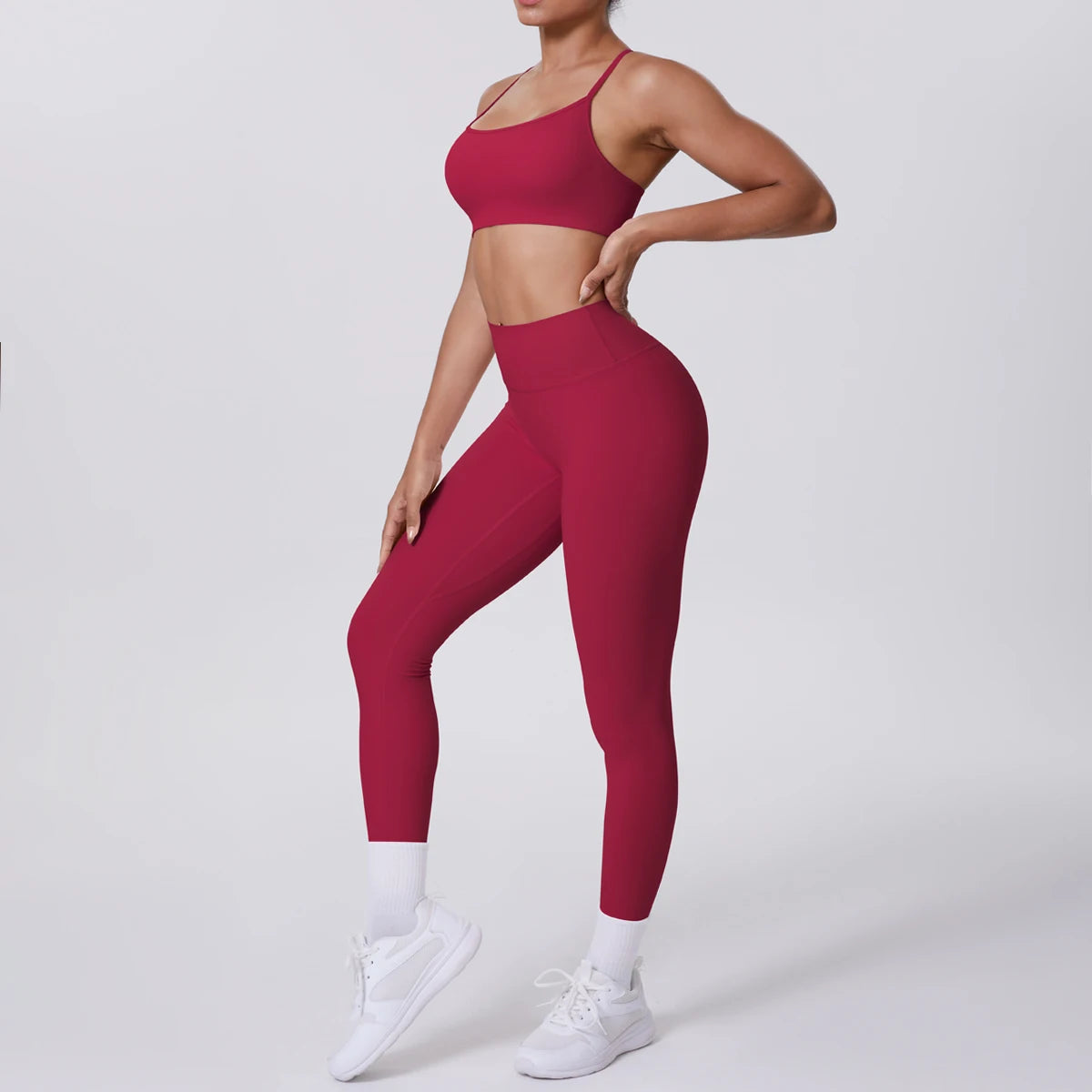 Person wearing a red sports bra and leggings set on a white background