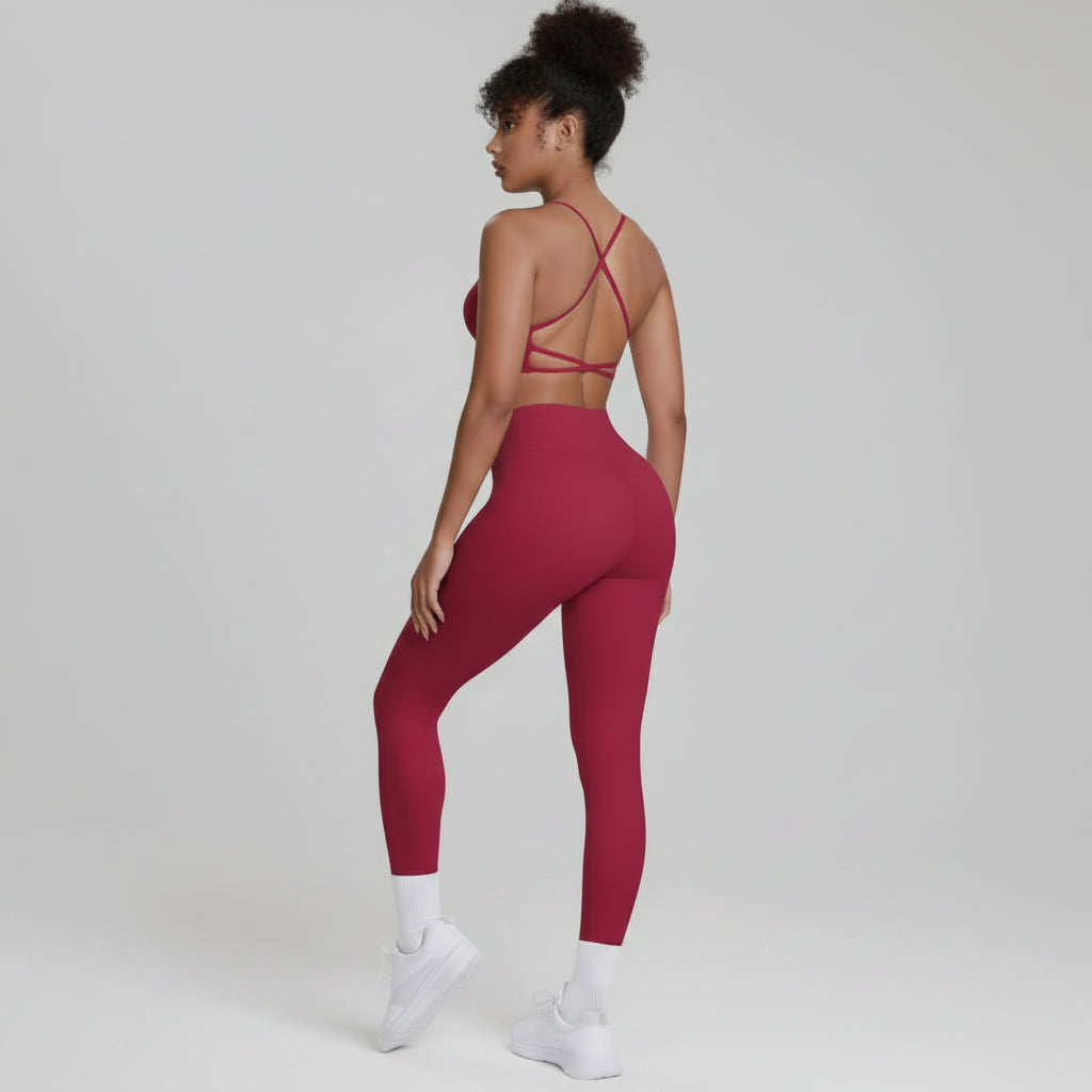 Person wearing a red sports bra and leggings set on a white background