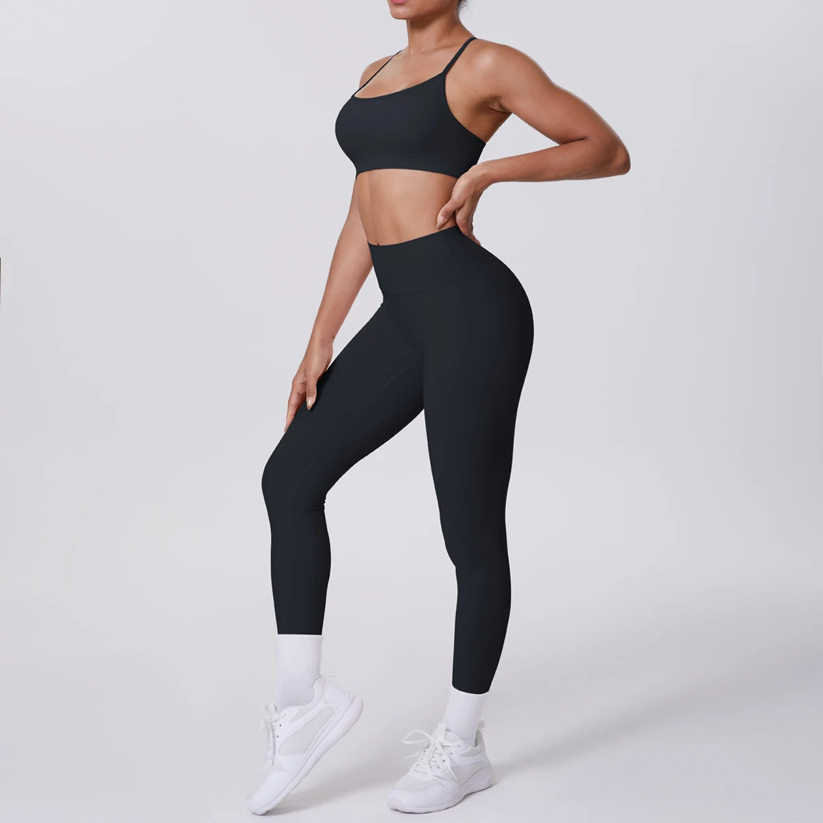 Person wearing black athletic bra and leggings on a white background
