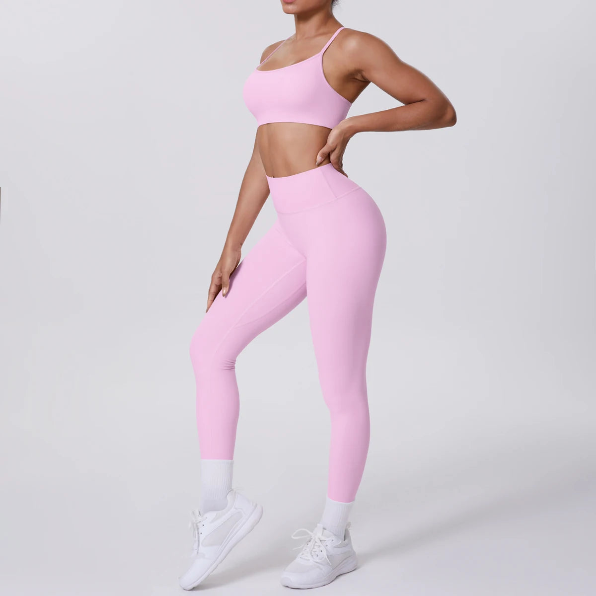 Person wearing pink sports bra and leggings on a light gray background