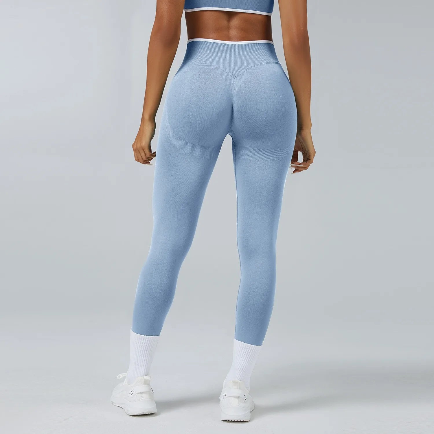 Person wearing light blue leggings on a gray background
