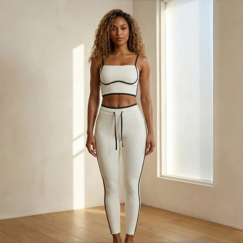 Woman wearing a white athletic outfit with black accents in a bright room.