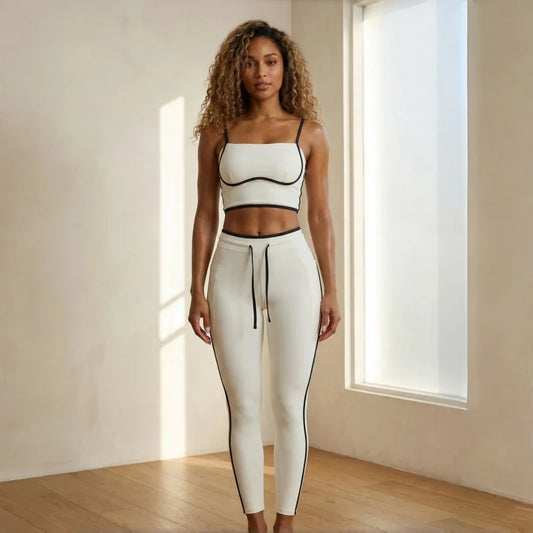 Woman wearing a white athletic outfit with black accents in a bright room.