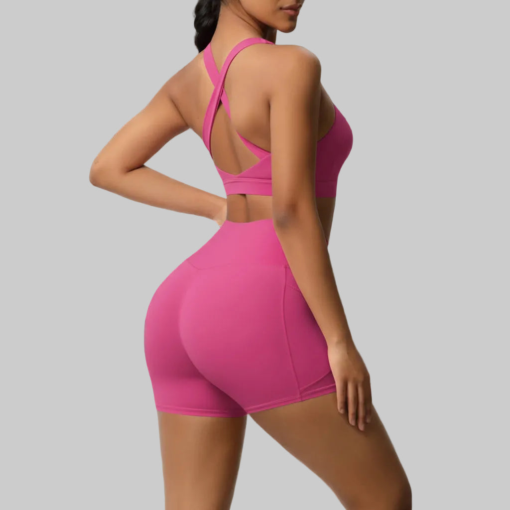 Woman wearing a pink sports outfit on a gray background