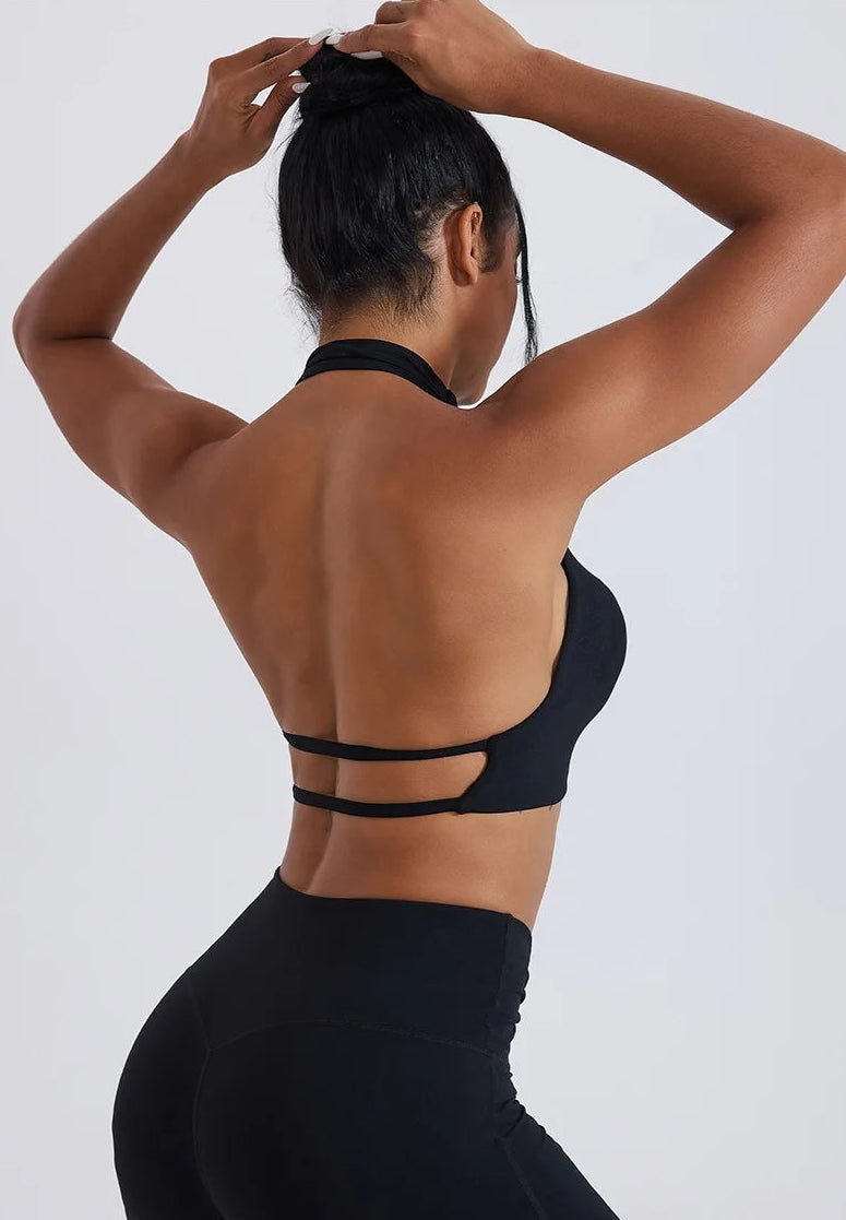 Person wearing a black sports bra and leggings against a white background